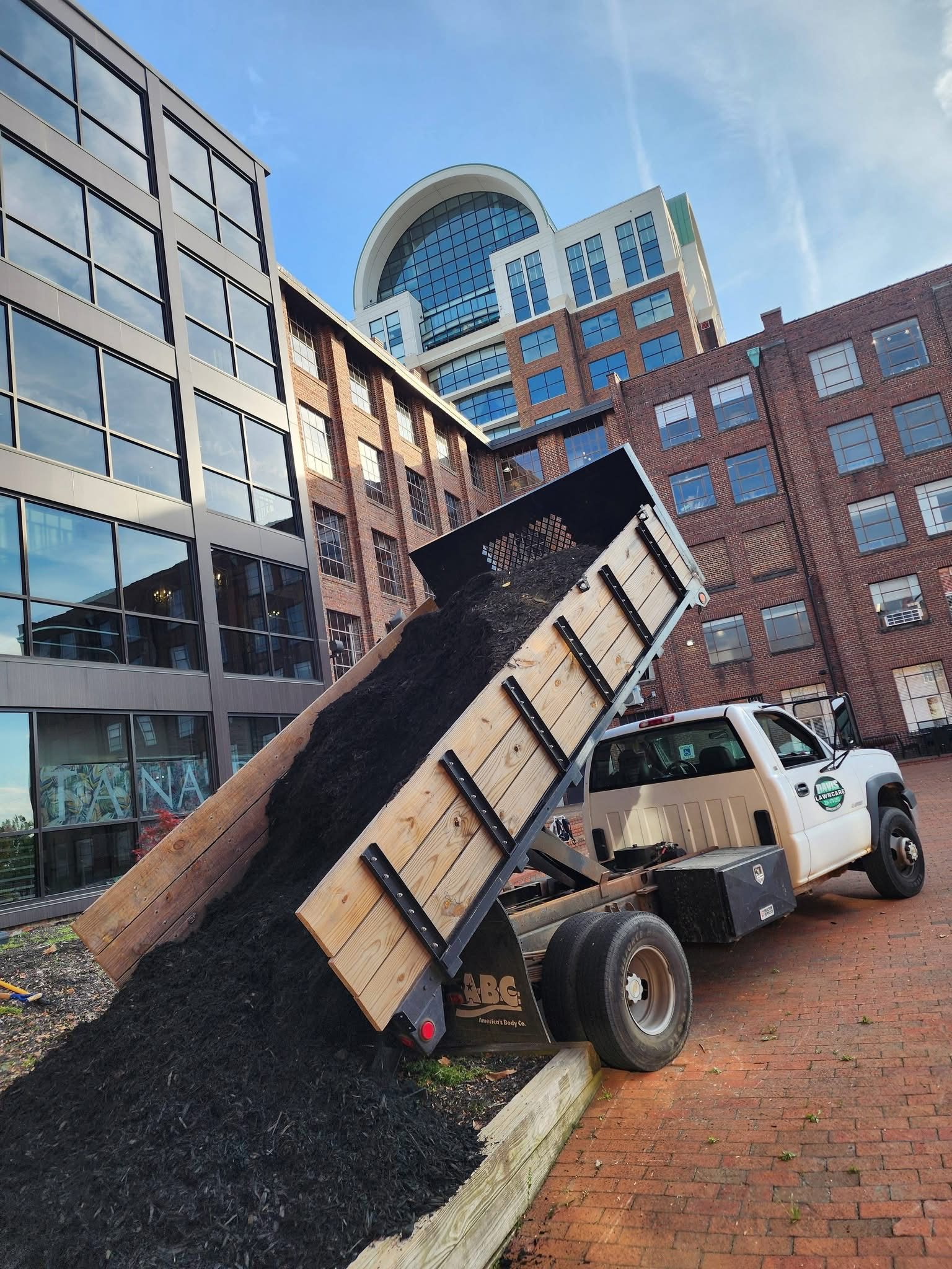 Davis Lawn Care truck delivering mulch at a commercial property