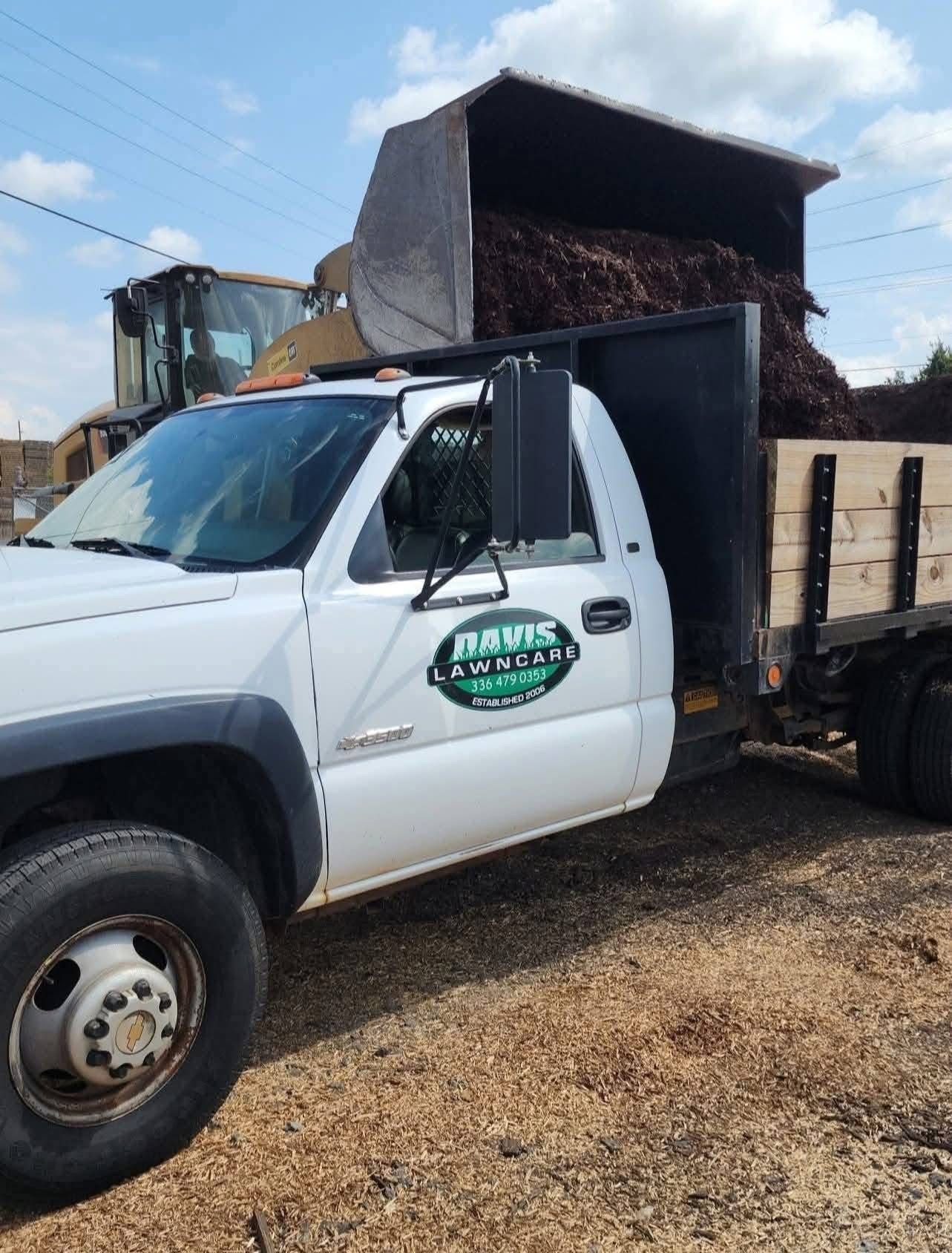Davis Lawn Care branded truck being loaded with mulch